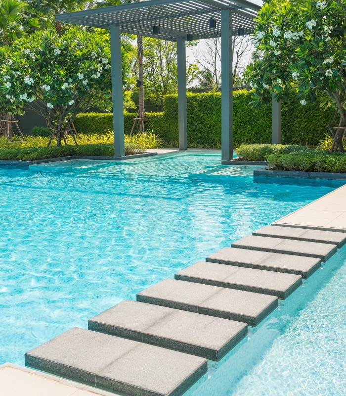 Piscine extérieure avec pas japonais et pergola dans un jardin paysager
