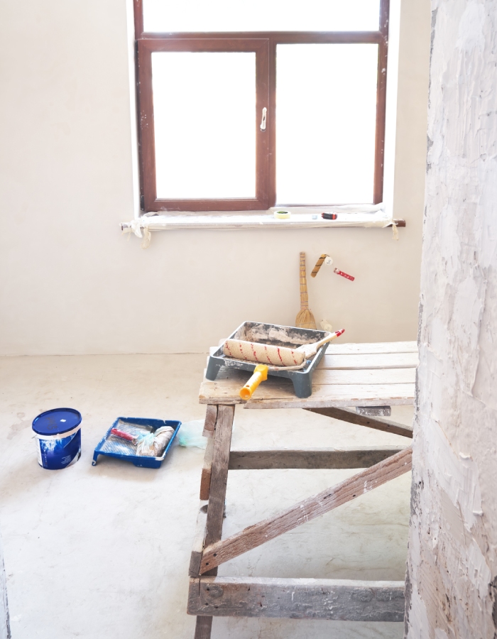 Pièce en rénovation avec outils de peinture et mur en préparation