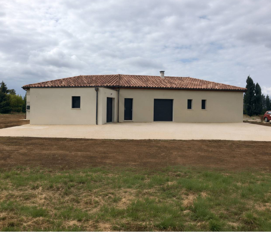 Maison individuelle construite par Bati-System avec toiture en tuiles et garage intégré
